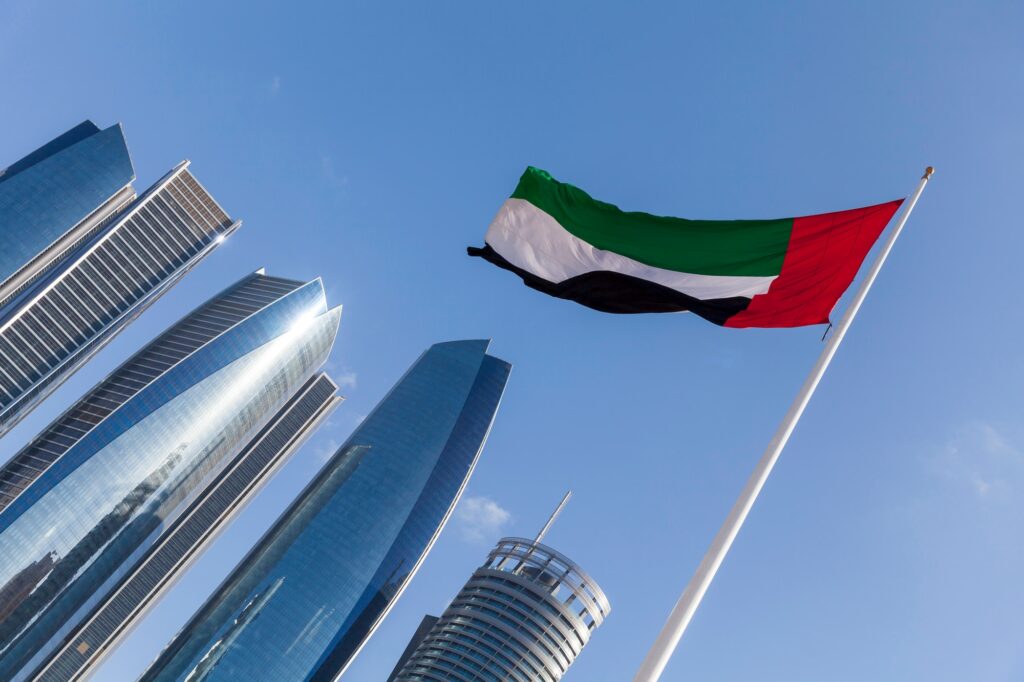 UAE flag with modern high rise buildings at the background in Abu Dhabi